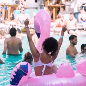 Woman relaxing on pink flamingo float at Bora Bora Pool Party Malta.