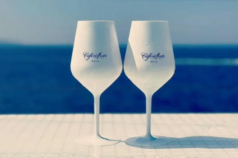 Un cocktail colorato su un tavolo vicino al mare al Cafe Del Mar Malta, catturando l'essenza dell'estate.