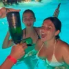 Women celebrating at a pool party at Cafe Del Mar Malta, spraying champagne with a champagne gun.