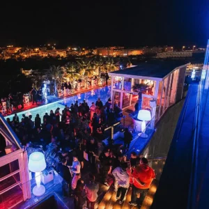 Aerial view of partygoers enjoying the lively rooftop scene at Hugo Hotel Malta, capturing the vibrant nightlife atmosphere.