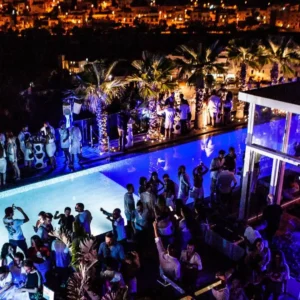 Partygoers gathered around the rooftop pool at Hugo Hotel Malta, enjoying the chic and lively atmosphere.