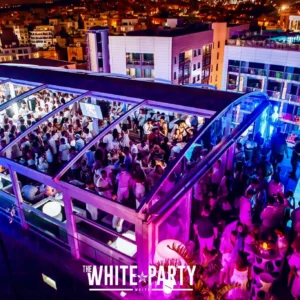 Aerial shot of the White Party at Hugo Hotel Malta, with partygoers dressed in white enjoying the stunning rooftop setting.