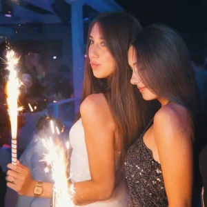 Two beautiful women holding sparklers, celebrating at Hugo Hotel Malta during an exclusive event.