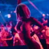 Performer in vibrant pink attire dancing on stage at Toy Room Malta.