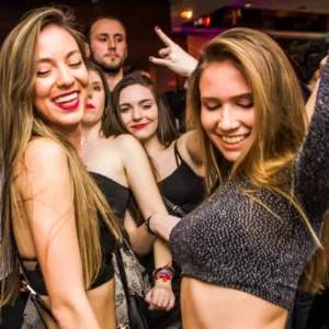 Young women enjoying the dance floor at Twenty Two Malta, surrounded by vibrant light effects creating an electrifying atmosphere.