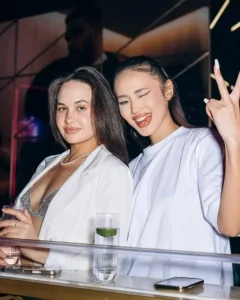 Two women dressed in elegant white outfits celebrating at the White Party at Twenty Two Malta.