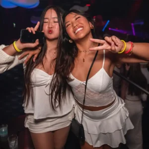 Two young women dressed in white enjoying the White Party at Twenty Two Malta, capturing the chic atmosphere of the event.
