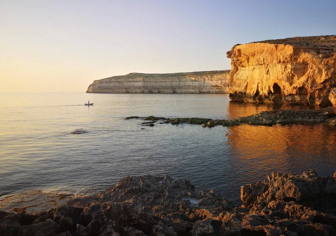 Dwejra Bay Gozo scogliere calcaree dorate tramonto kayak acqua calma