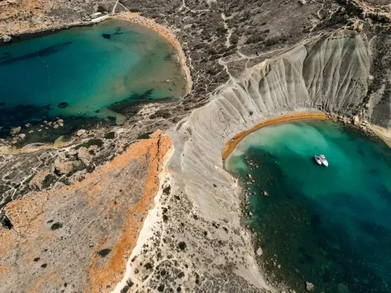 Aerial drone view of Ghajn Tuffieha and Qarraba Bay twin coves separated by dramatic clay cliffs in Malta