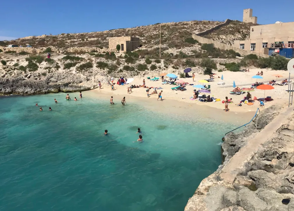spiaggia Hondoq ir-Rummien Gozo caletta sabbiosa nuotatori acqua turchese