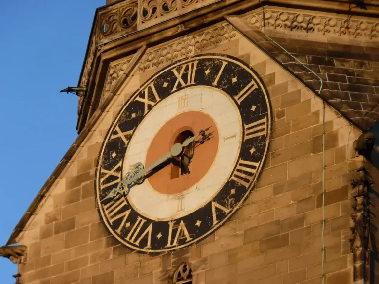 Horloge en pierre d'une église maltaise affichant l'heure en chiffres romains sur une façade en calcaire