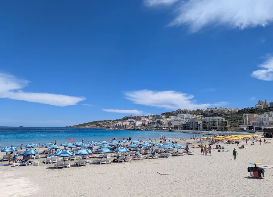 Mellieha Bay Ghadira Malta spiaggia sabbia bianca ombrelloni a righe blu mare