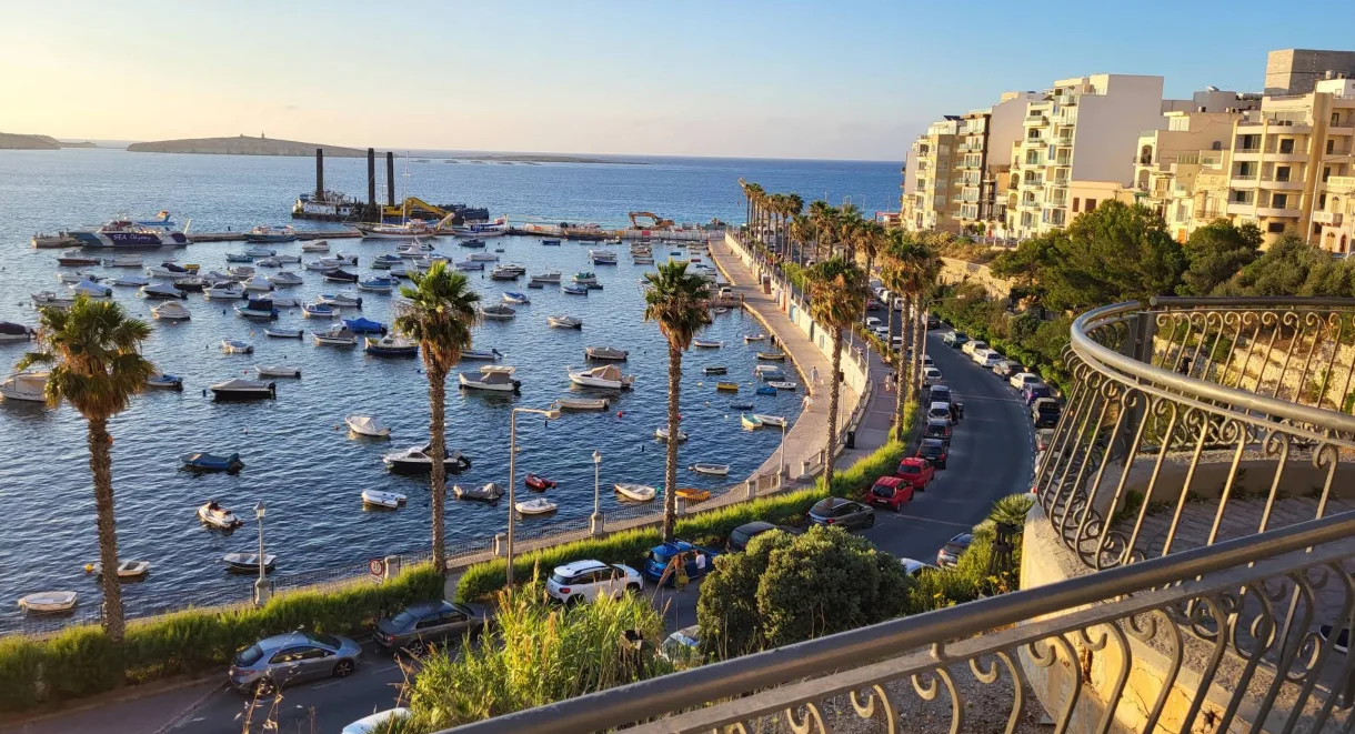 lungomare porto Mellieha tramonto palme barche luce dorata Malta nord