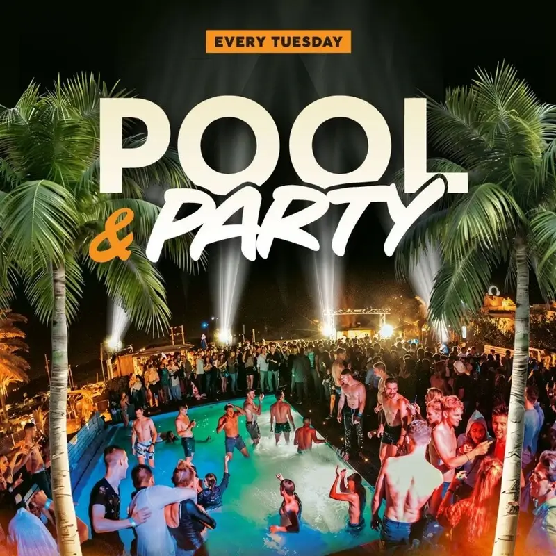 Night view of the illuminated open-air rooftop pool party at Gianpula Village in Malta with Mdina visible in the background.