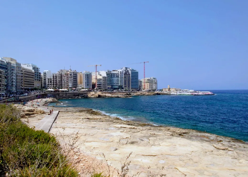 Qui-Si-Sana beach Sliema Malta vista 2 – nuotatori che godono del lido roccioso al tramonto