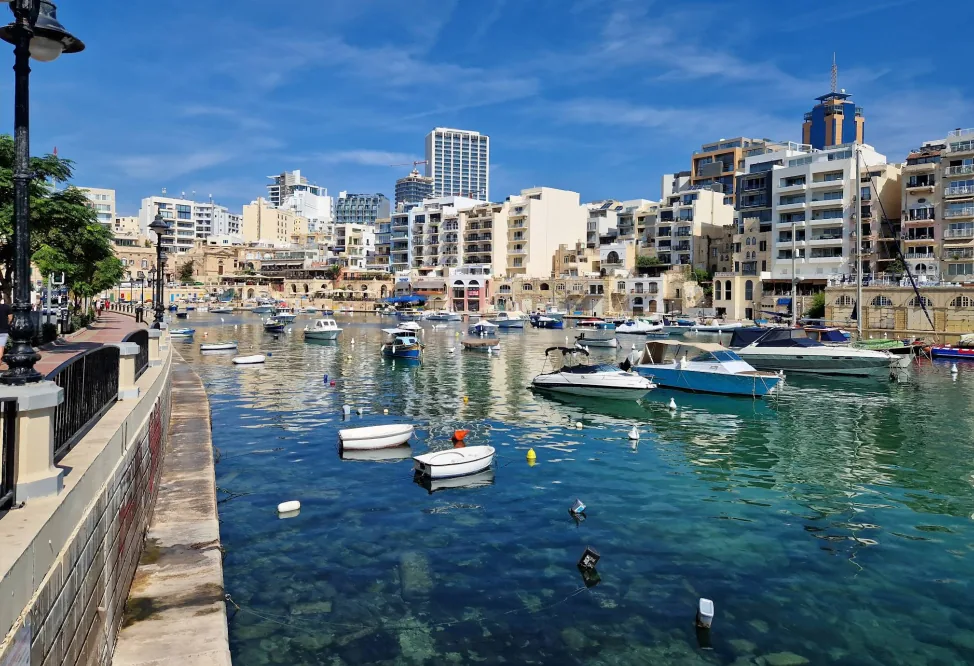Spinola Bay St Julian's Malta – colorati luzzu tradizionali maltesi sull'acqua calma della baia