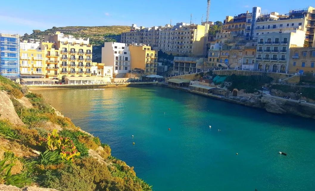 Xlendi Bay Gozo ora dorata acqua smeraldo edifici calcare miele